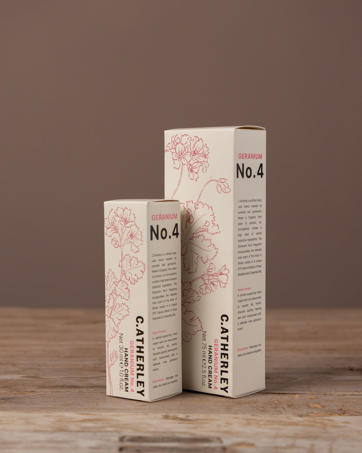 Two boxes of C. Atherley hand cream on a wooden surface with a brown background