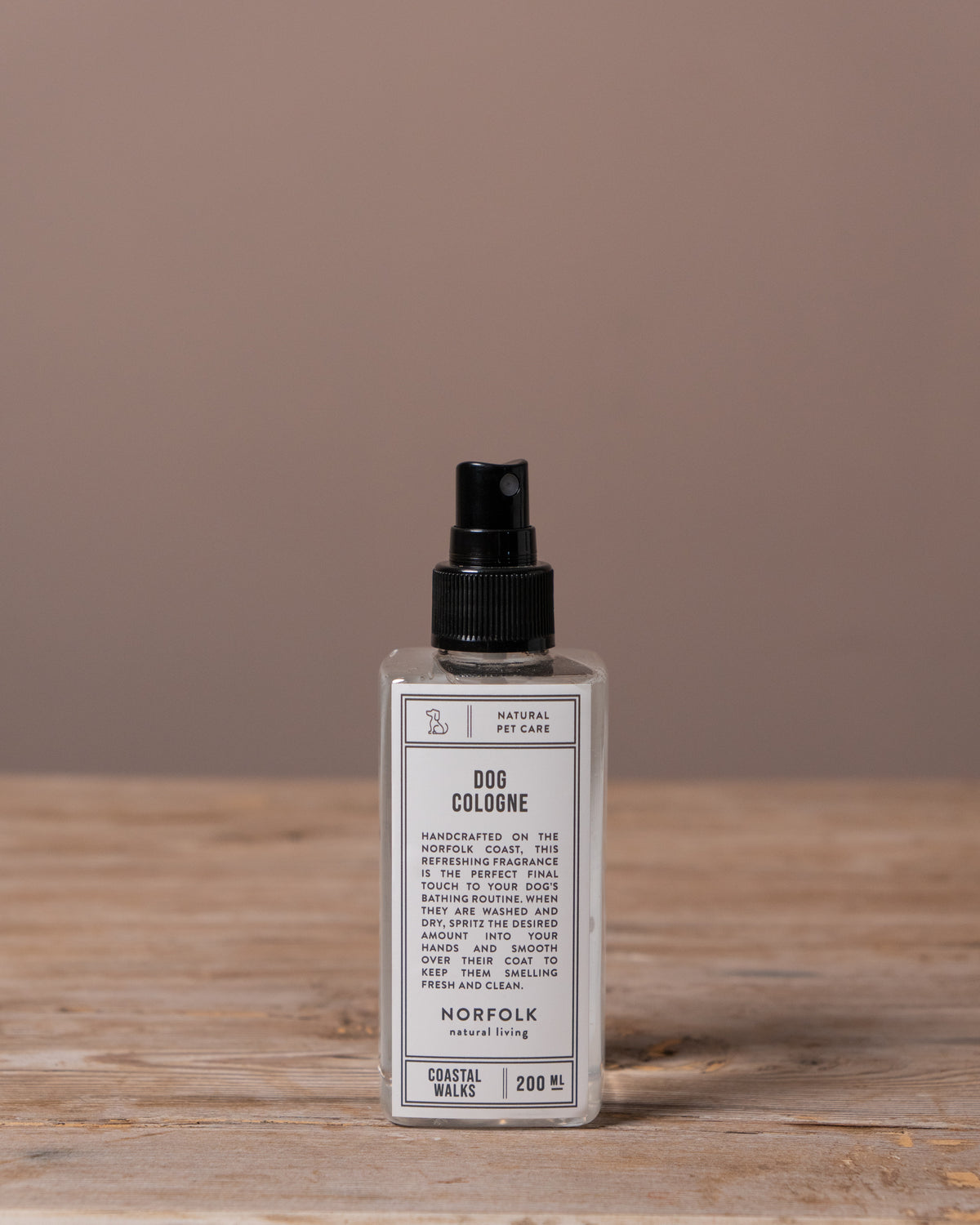 Dog cologne bottle on a wooden surface with a brown background