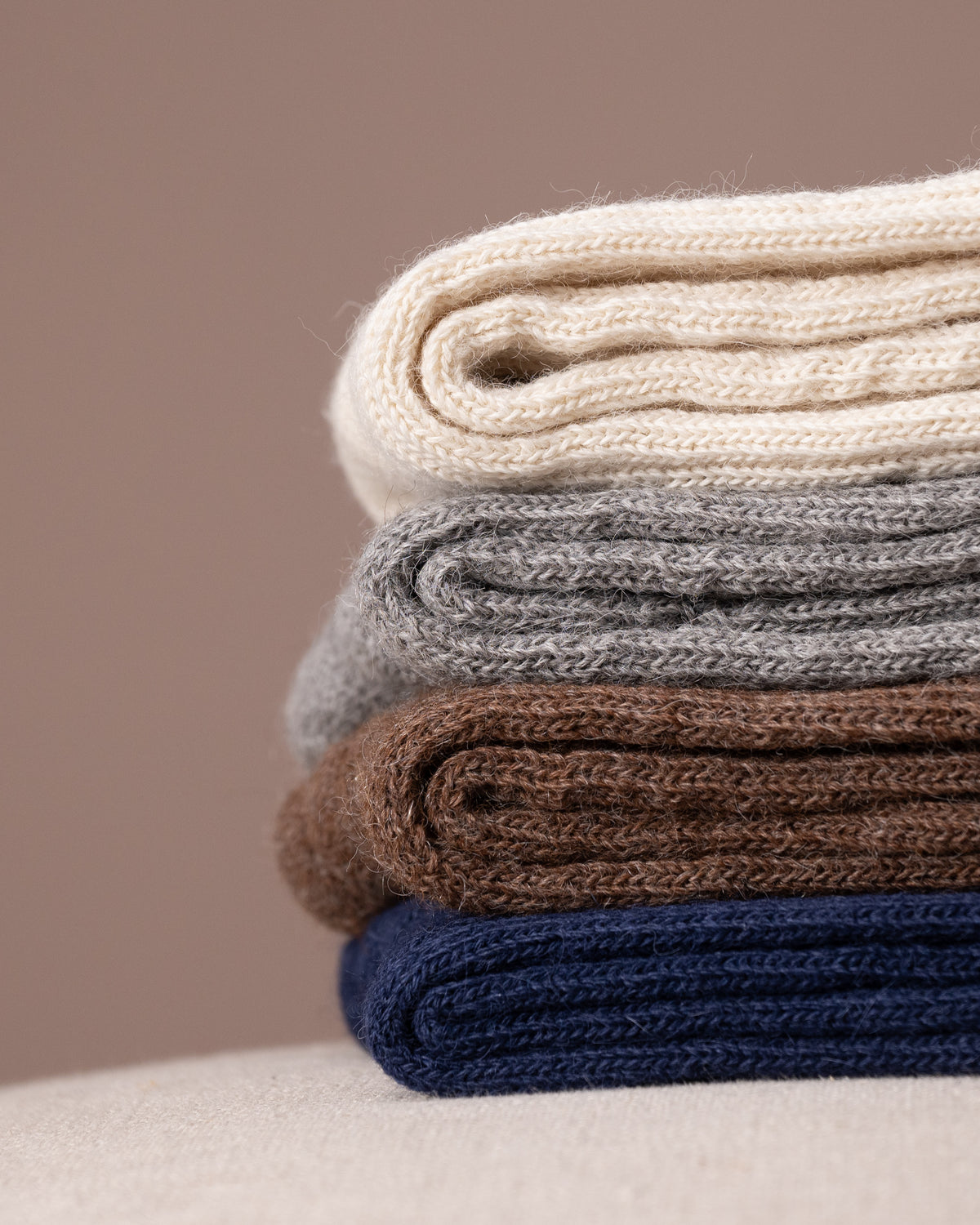 Stack socks in various colours on a neutral background
