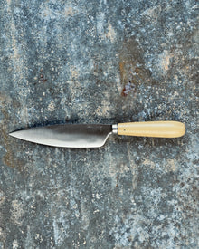 Knife with a wooden handle on a textured stone surface