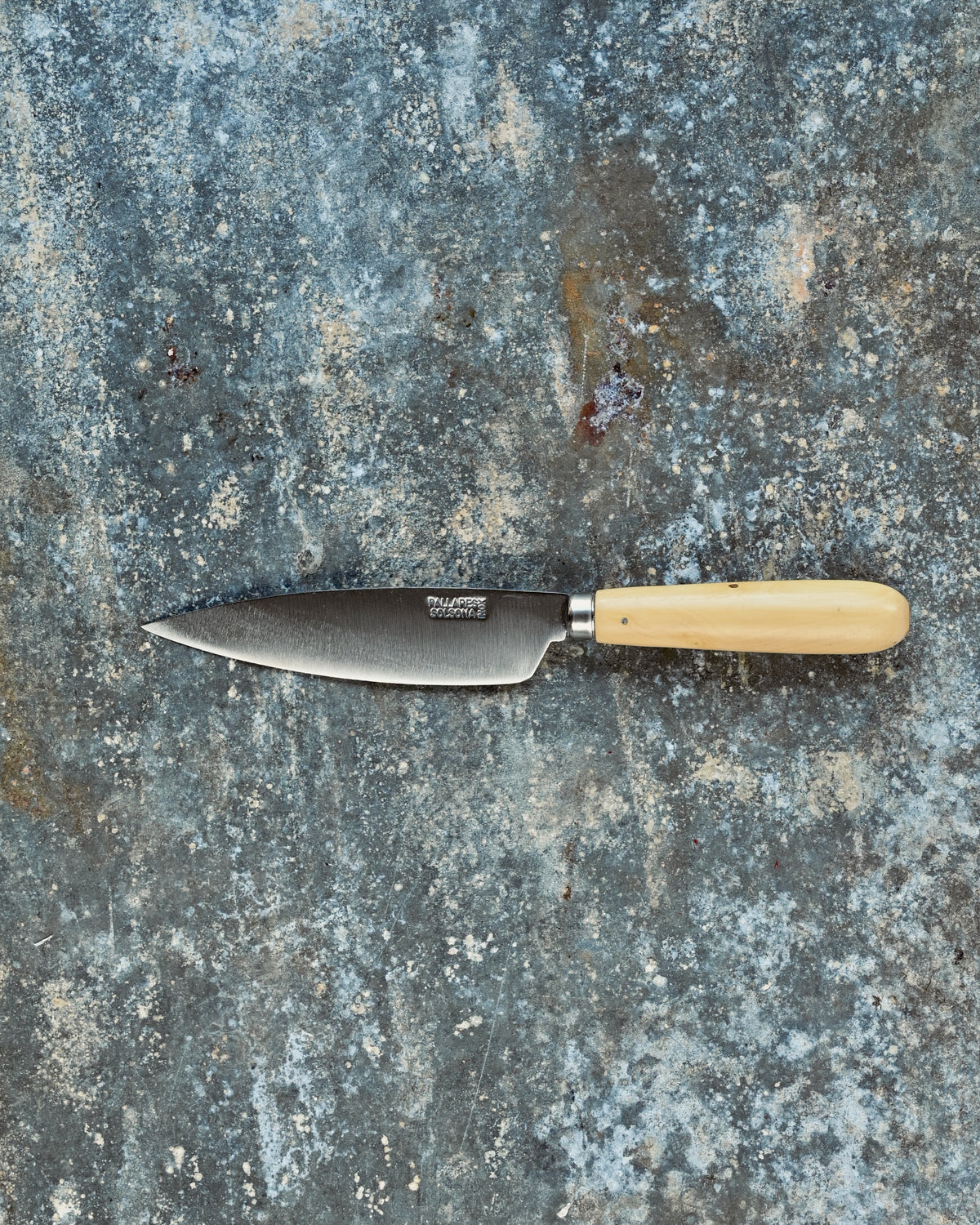 Knife with a wooden handle on a textured stone surface