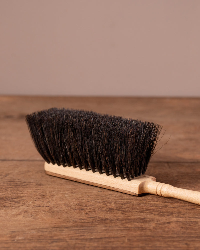 Brush with black bristles on a wooden surface
