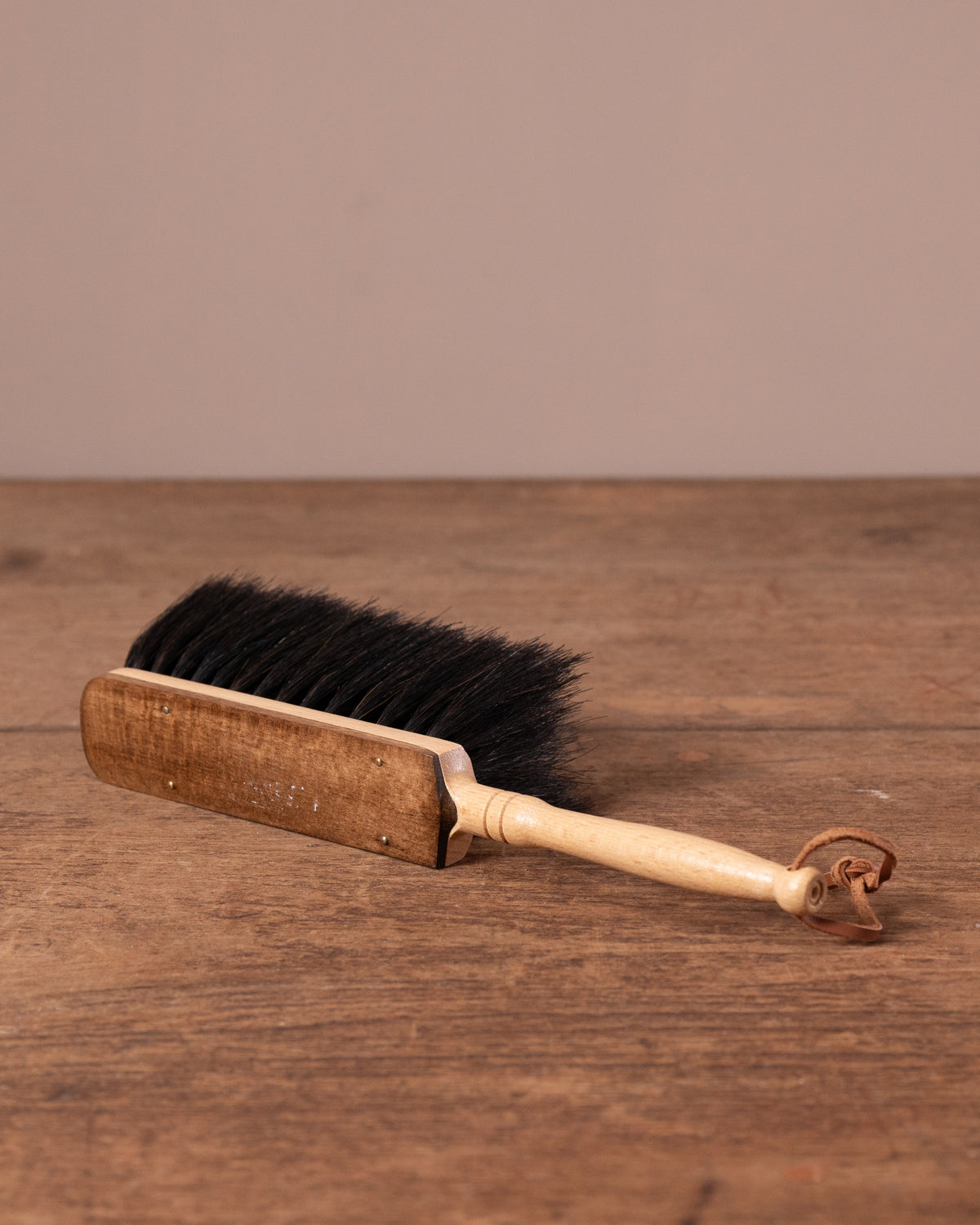 Wooden brush with black bristles on a wooden surface