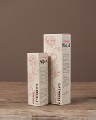 Two boxes of C. Atherley hand cream on a wooden surface with a brown background