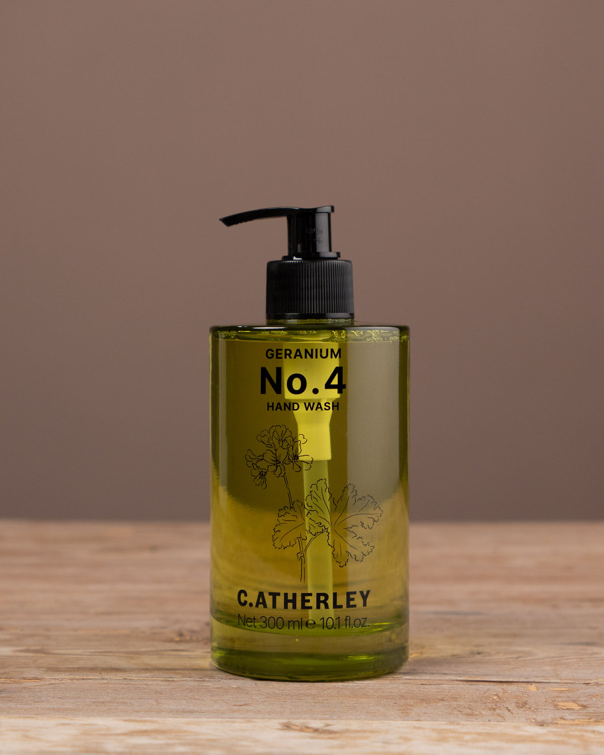 Bottle of C. Atherley No. 4 hand wash on a wooden surface with a brown background