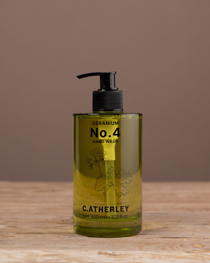 Bottle of C. Atherley No. 4 hand wash on a wooden surface with a brown background