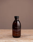 Brown bottle with black cap on a wooden surface and brown background