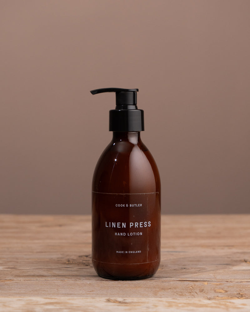 Brown bottle with black pump on a wooden surface and brown background