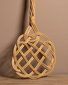 Carpet beater on a wooden surface with a brown background