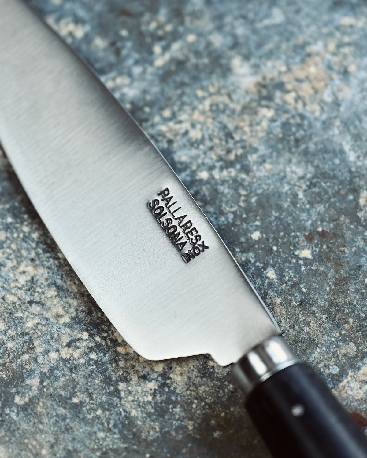 Knife with a brand logo on a textured surface
