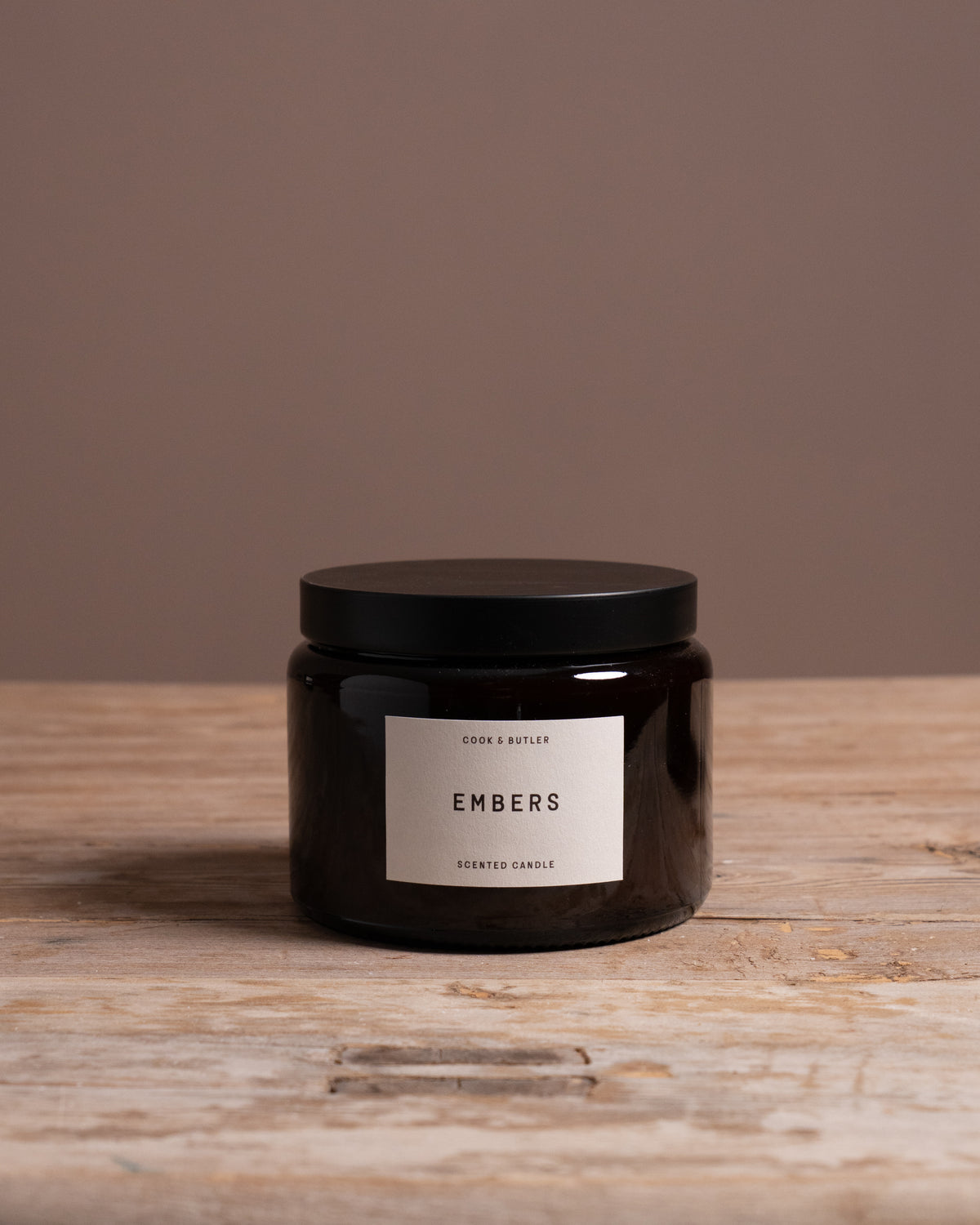 Cook & Butler scented candle on a wooden table