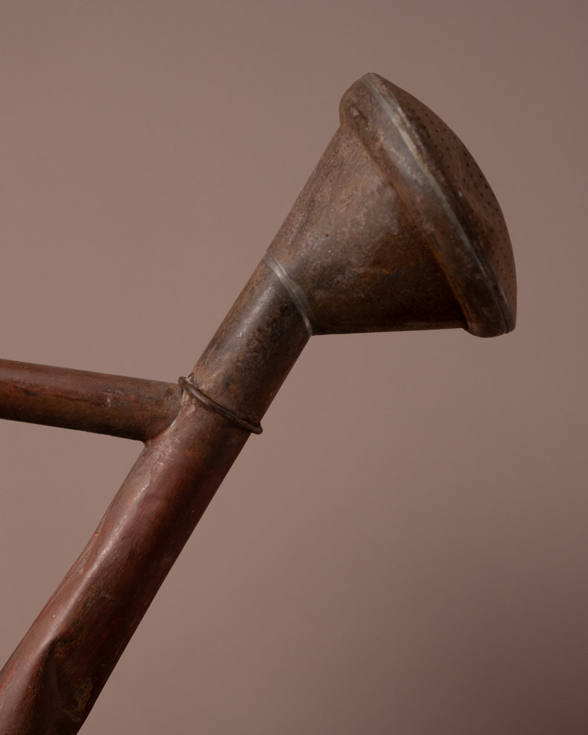 Close-up of a metal funnel with a brown background
