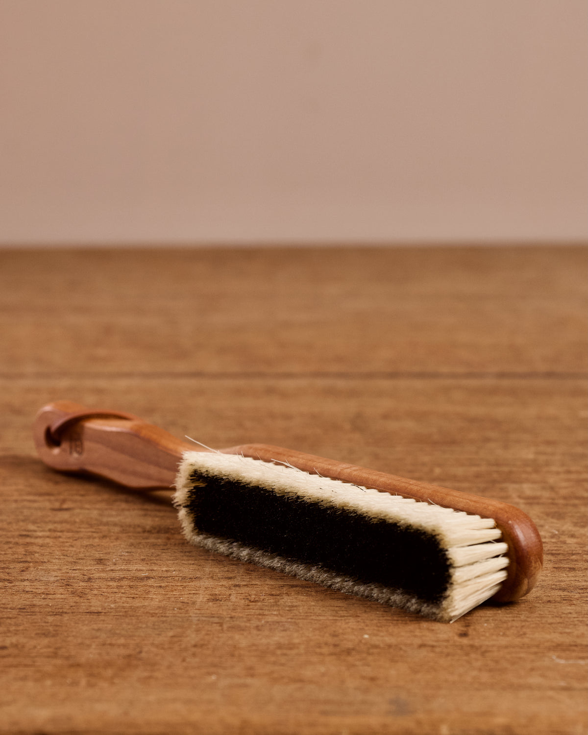 Wooden brush with bristles on a wooden surface