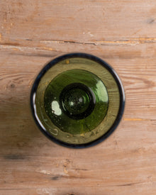 Green glass on a wooden surface