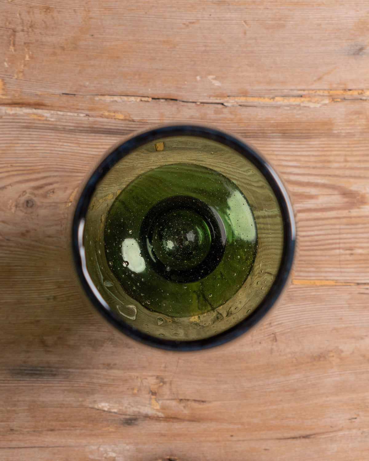 Green glass on a wooden surface