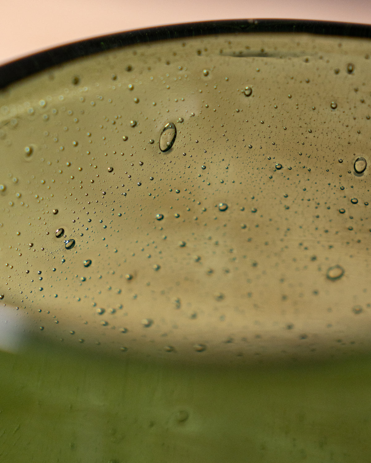 Close-up of a green glass with bubbles in a container