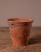 Terracotta pot on a wooden surface with a brown background