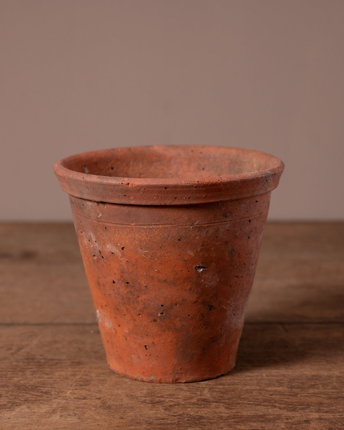 Terracotta pot on a wooden surface with a brown background