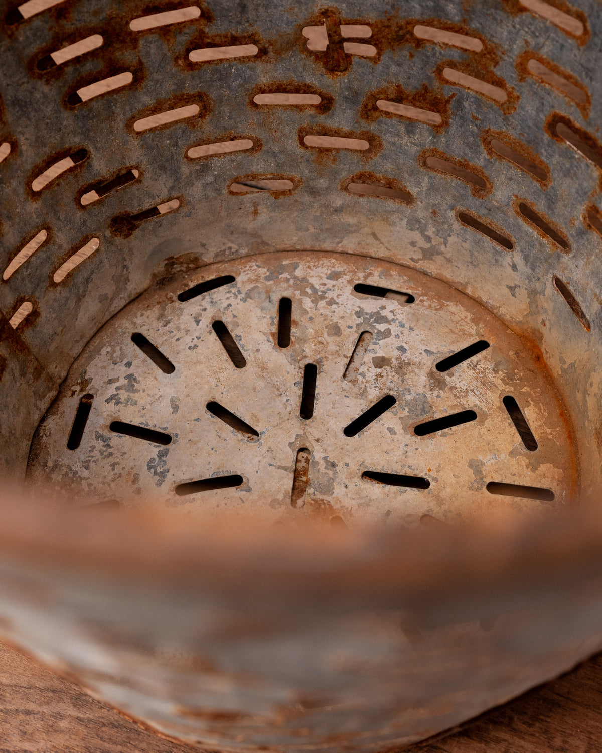 Close-up of a rusty metal drain cover with circular pattern