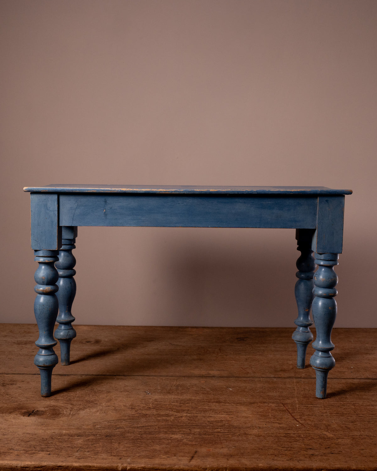 Blue wooden table against a brown wall