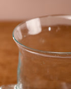 Clear glass container with a brownish liquid on a wooden surface