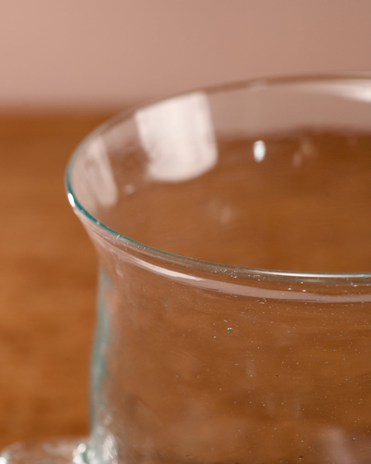 Clear glass container with a brownish liquid on a wooden surface