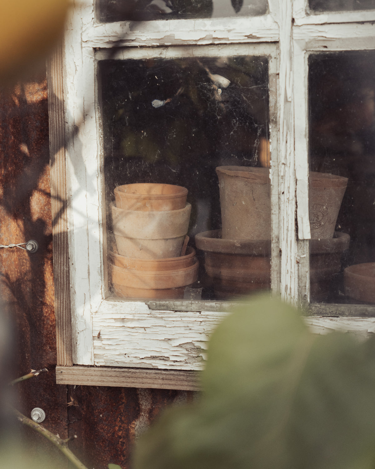 Stack of terracotta pots inside a rustic window