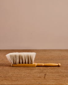 Wooden brush with white bristles on a wooden surface