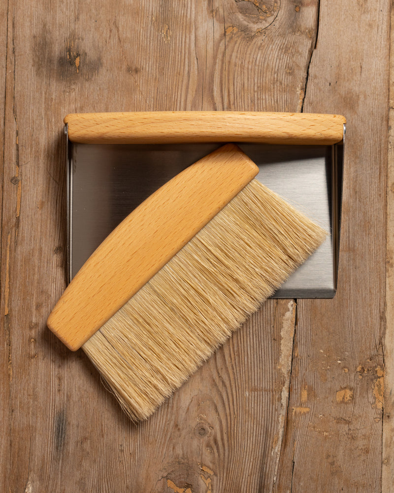 Wooden brush with a metal handle on a wooden surface