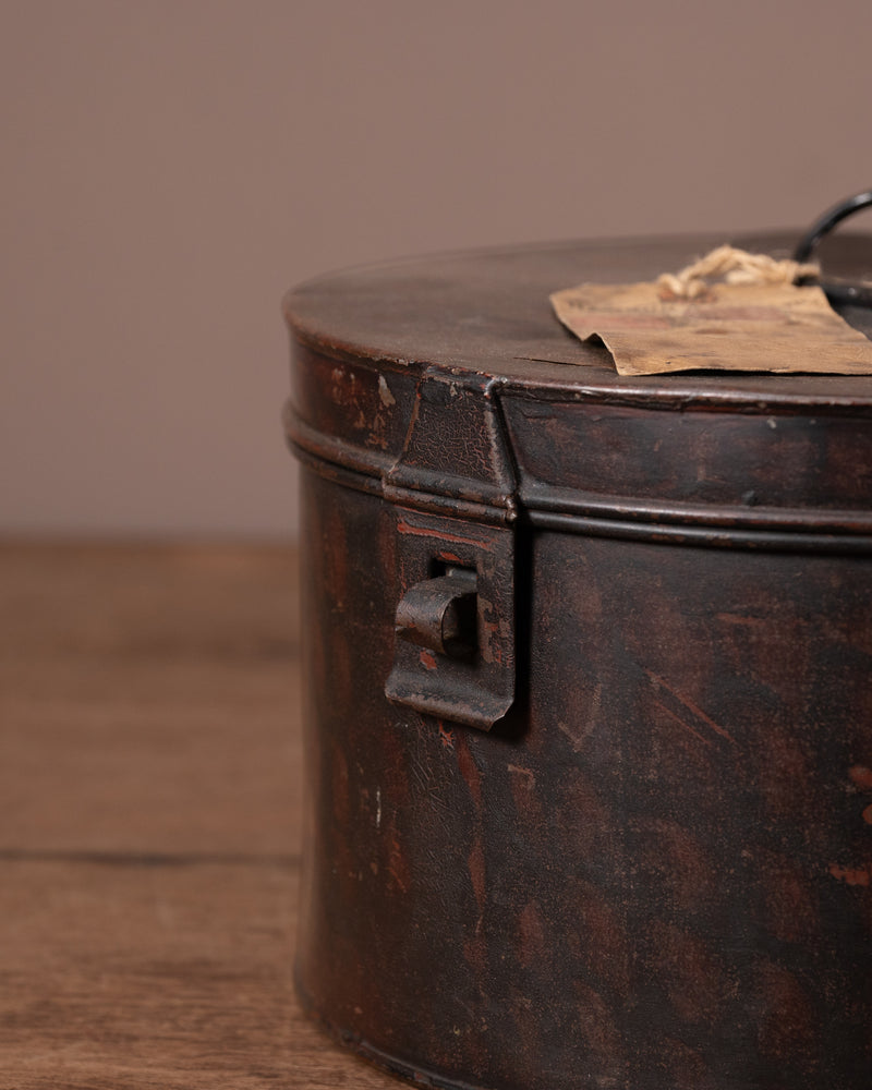 Vintage metal canister with a lid on a wooden surface
