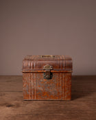 Vintage brown leather suitcase on a wooden surface with a plain background